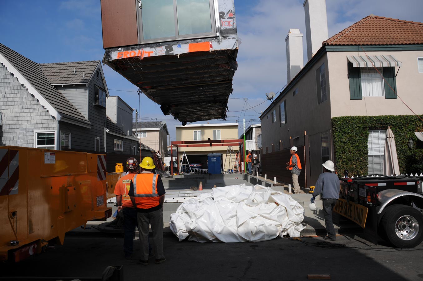 <p>A crane lowers the first of four modules onto a thin lot. Installation was complete in a single day. <br><small>&copy; LivingHomes</small></p>